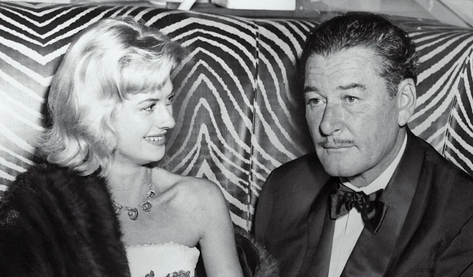 Teen Beverly Aadland at a nightclub with Errol Flynn, smiling as she looks at him
