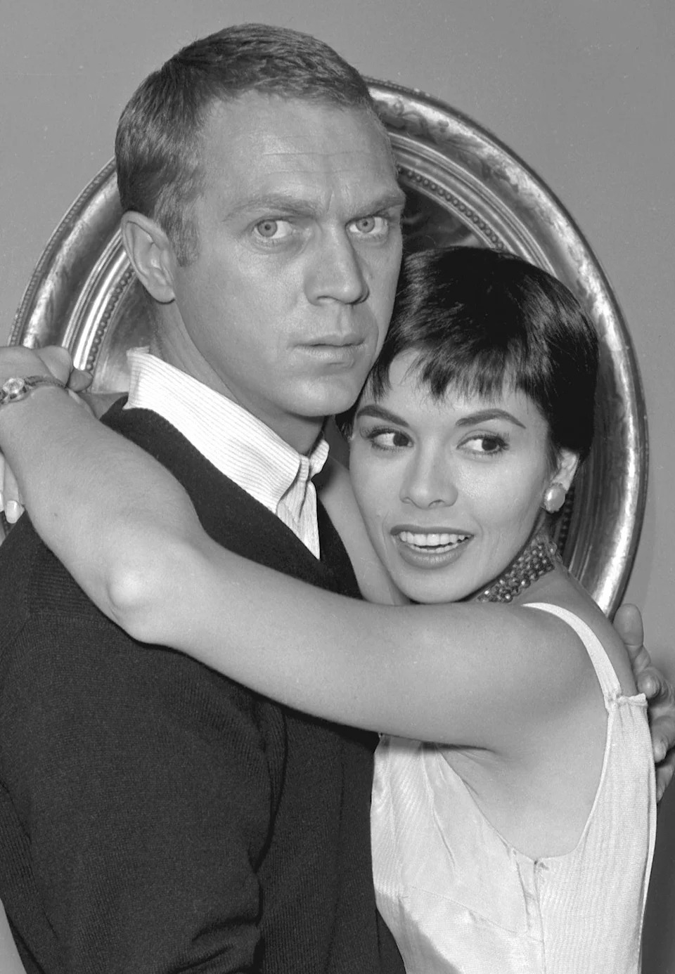 Steve McQueen and Neile Adams embracing while wearing formalwear